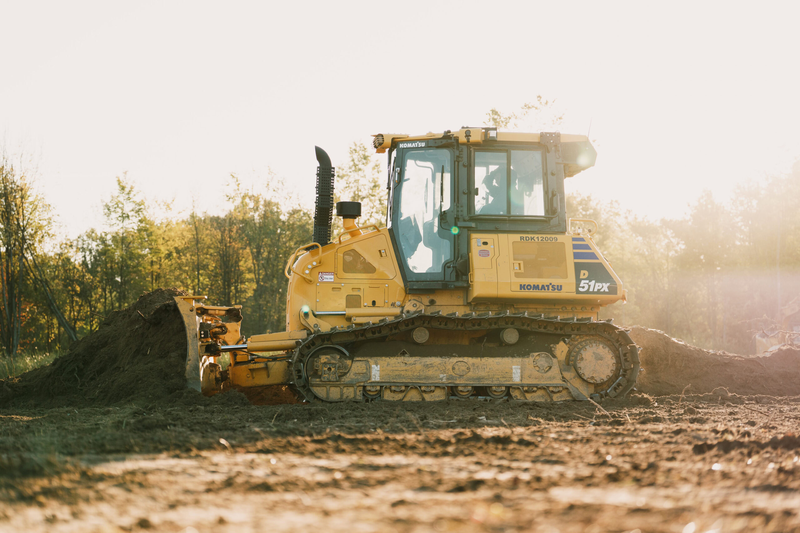 J.Green-DQ-47 Yellow bulldozer working on a construction site during daytime.
