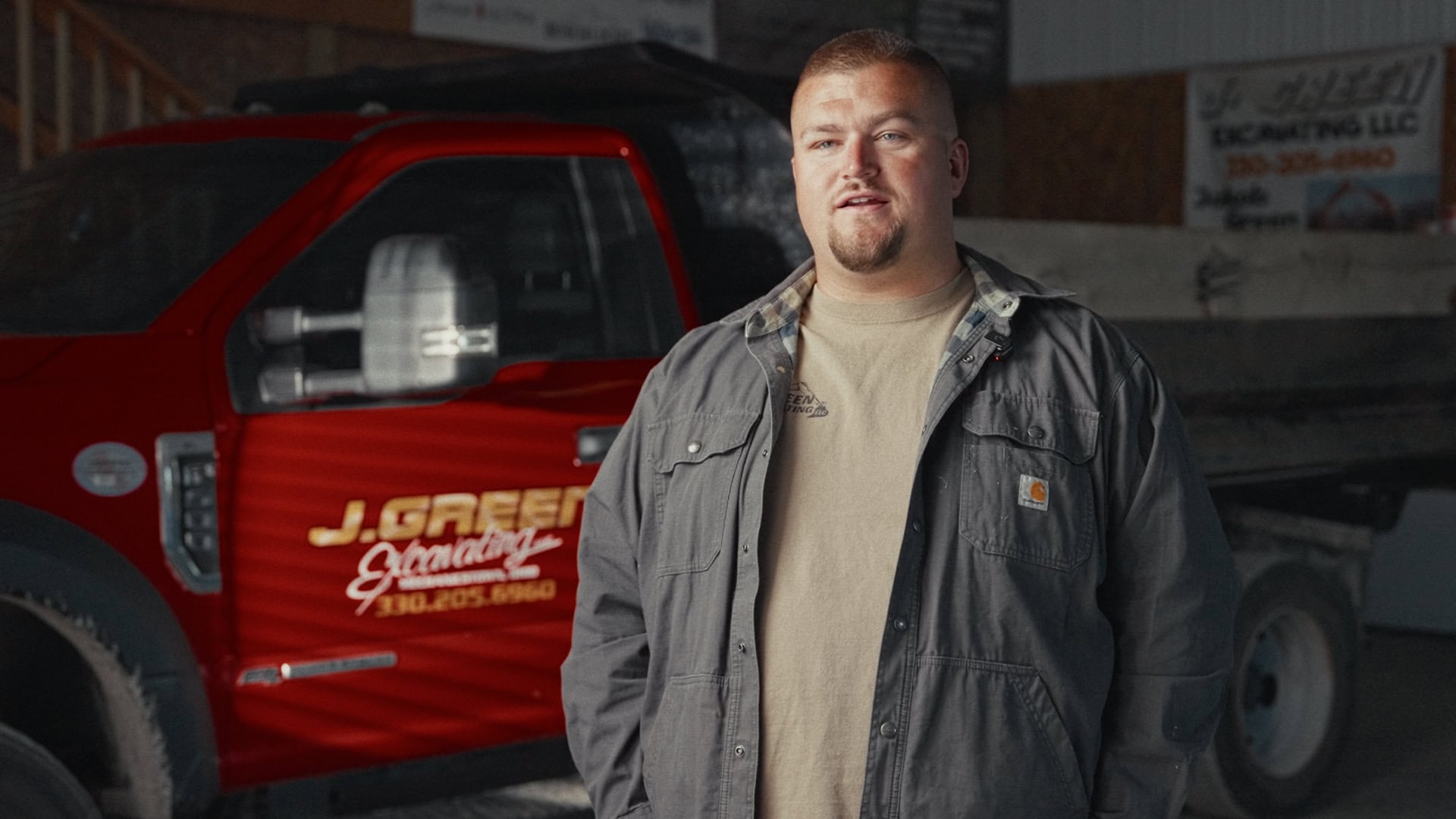 JGreen Man standing next to a red work truck with company logo in Northeast Ohio.