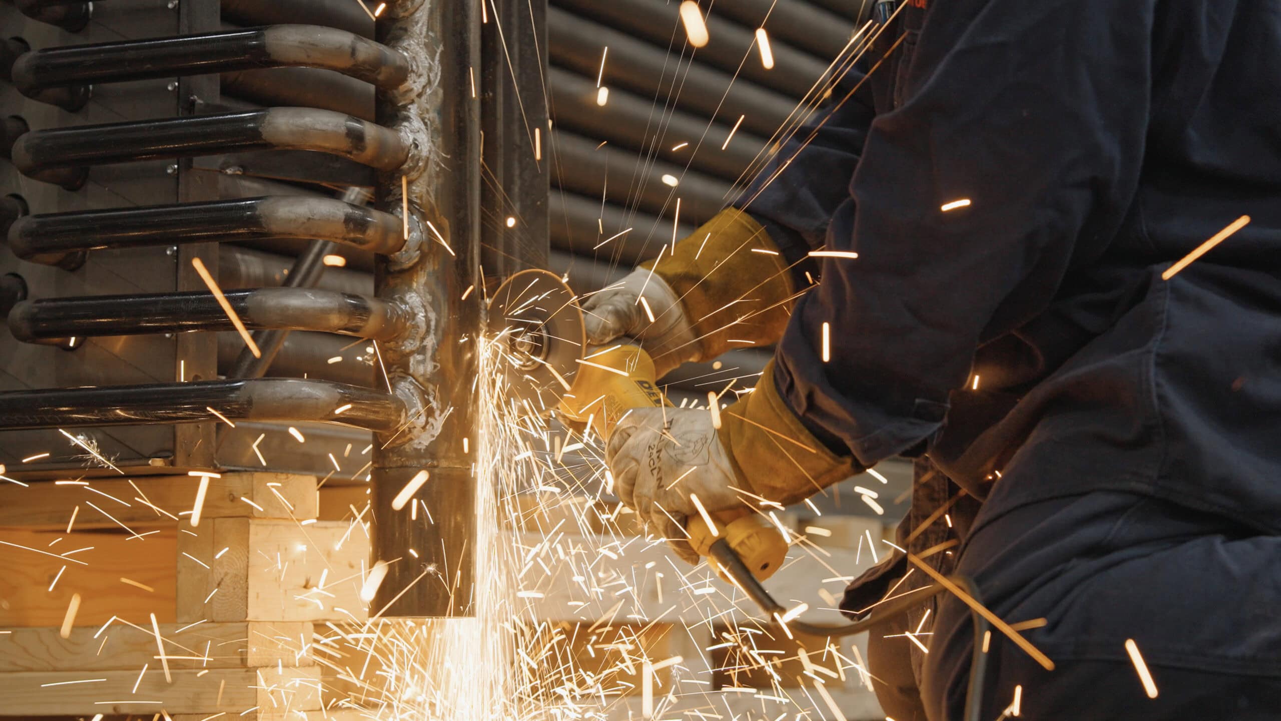 Screenshot 2026-08-20 at 3.45.07 PM Worker welding metal with sparks flying in industrial workshop.