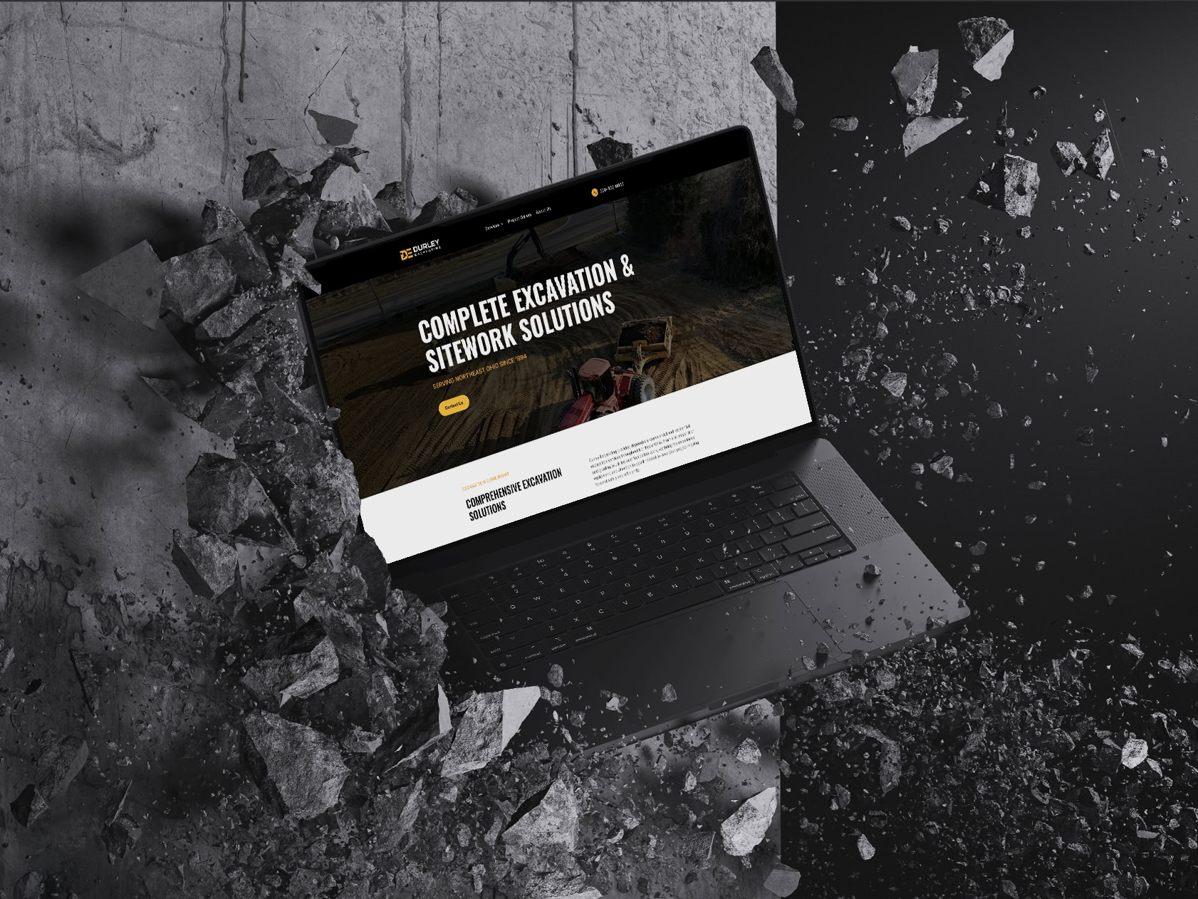 Laptop with website on excavation and sitework solutions breaking through concrete.