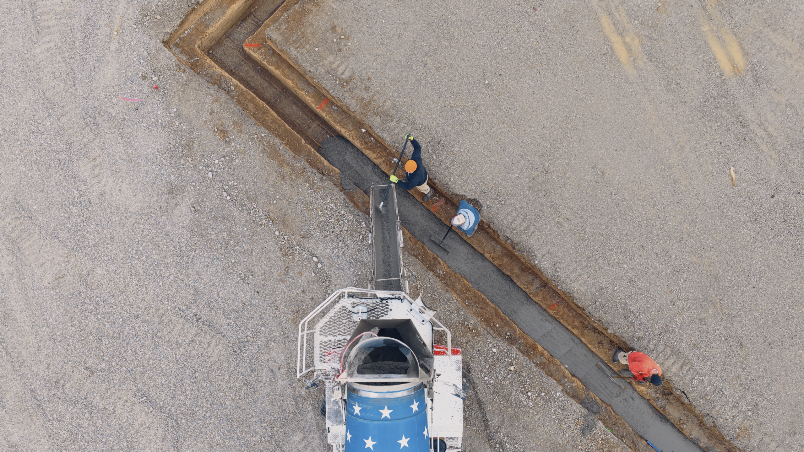 Screenshot 2026-09-24 at 5.17.14 PM Worker installing underground utility lines in a construction site.